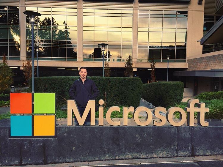Alex behind a Microsoft logo